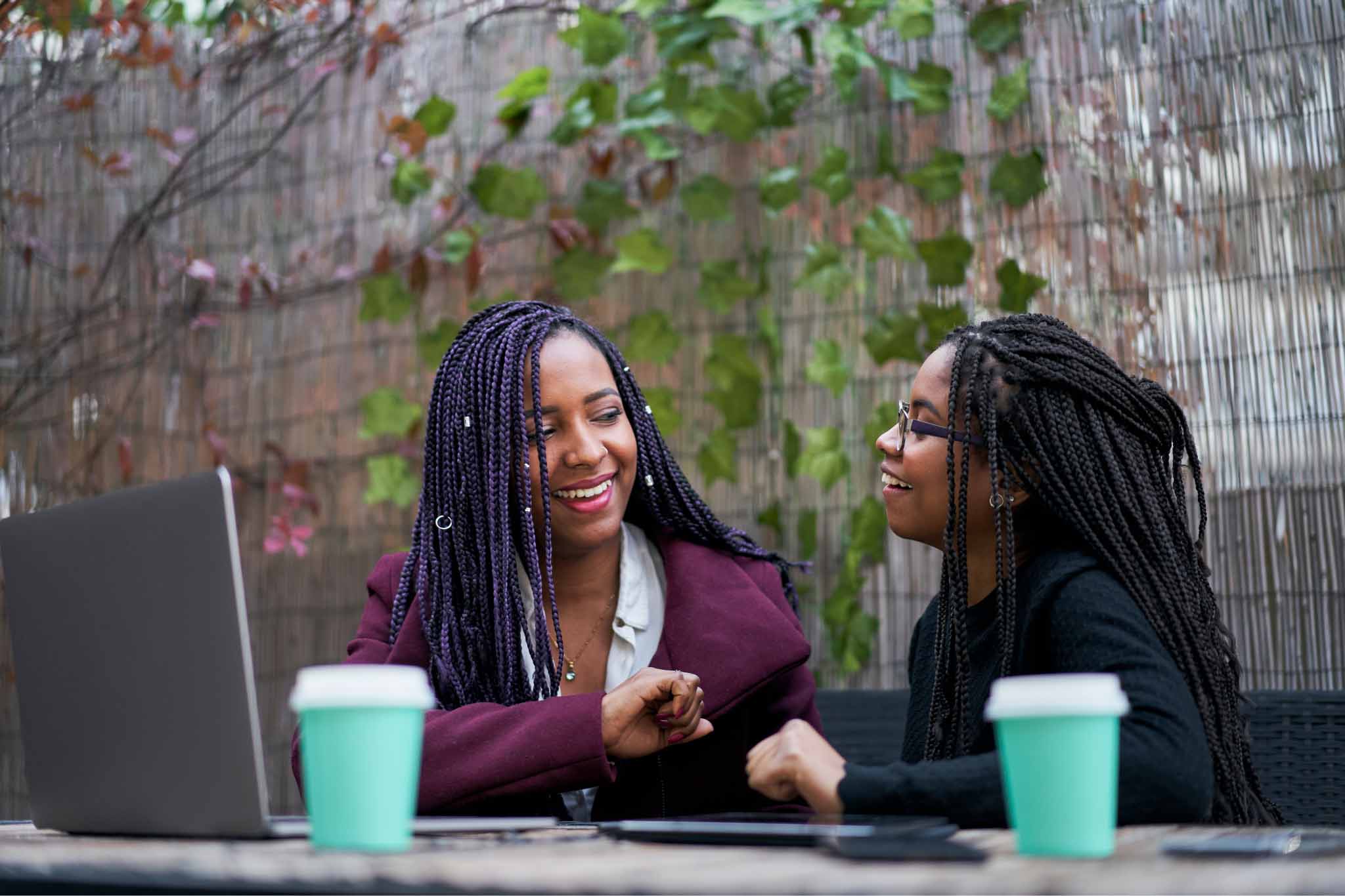 two-young-women-working-on-laptop-making-jokes